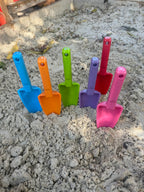 group-photo-coloured-trowels-kids-sitting-in-sand-beach-tools