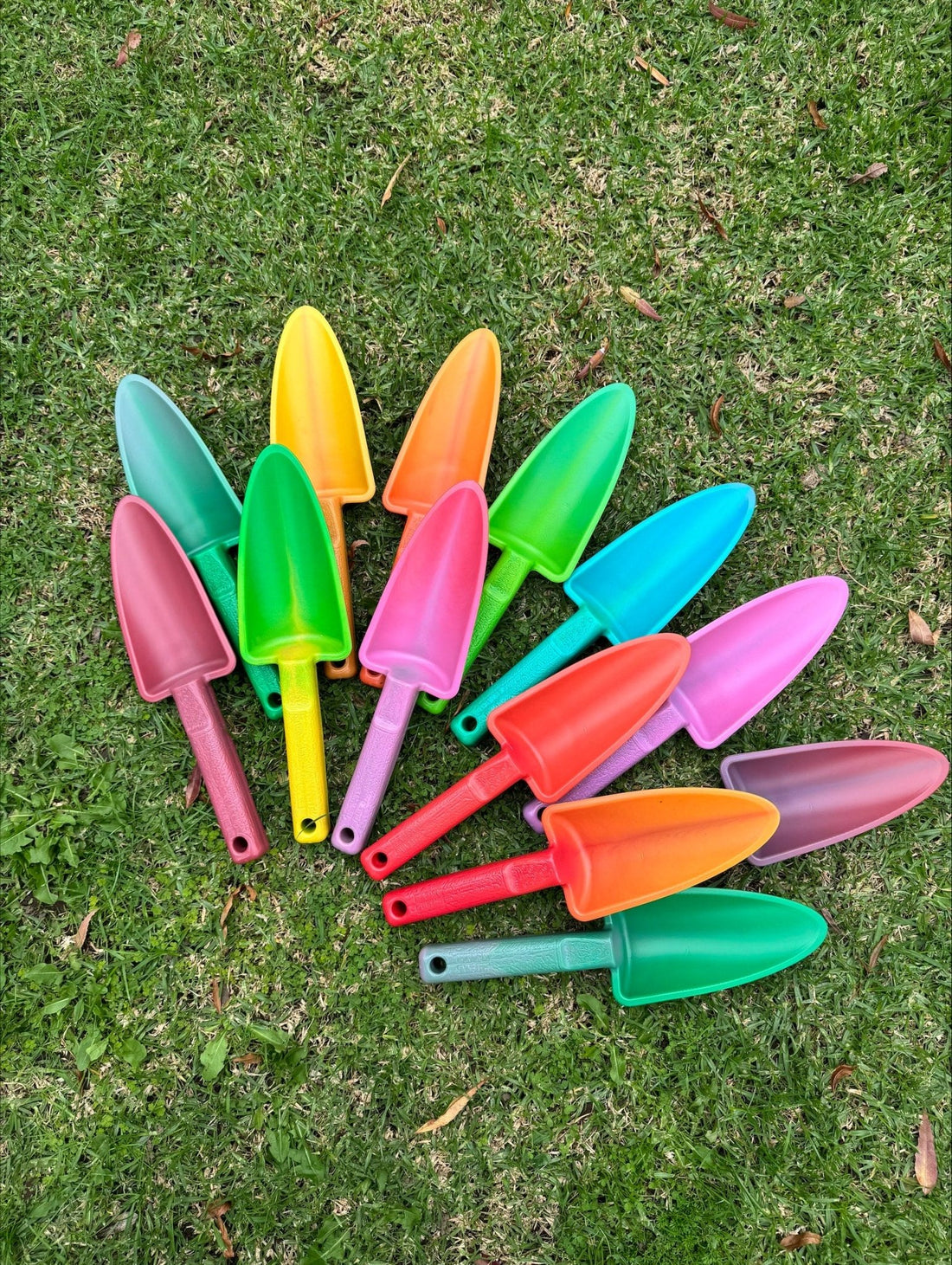 Group-shot-recycled-plastic-garden-trowels-in-bright-mixed-colours-laying-on-grass