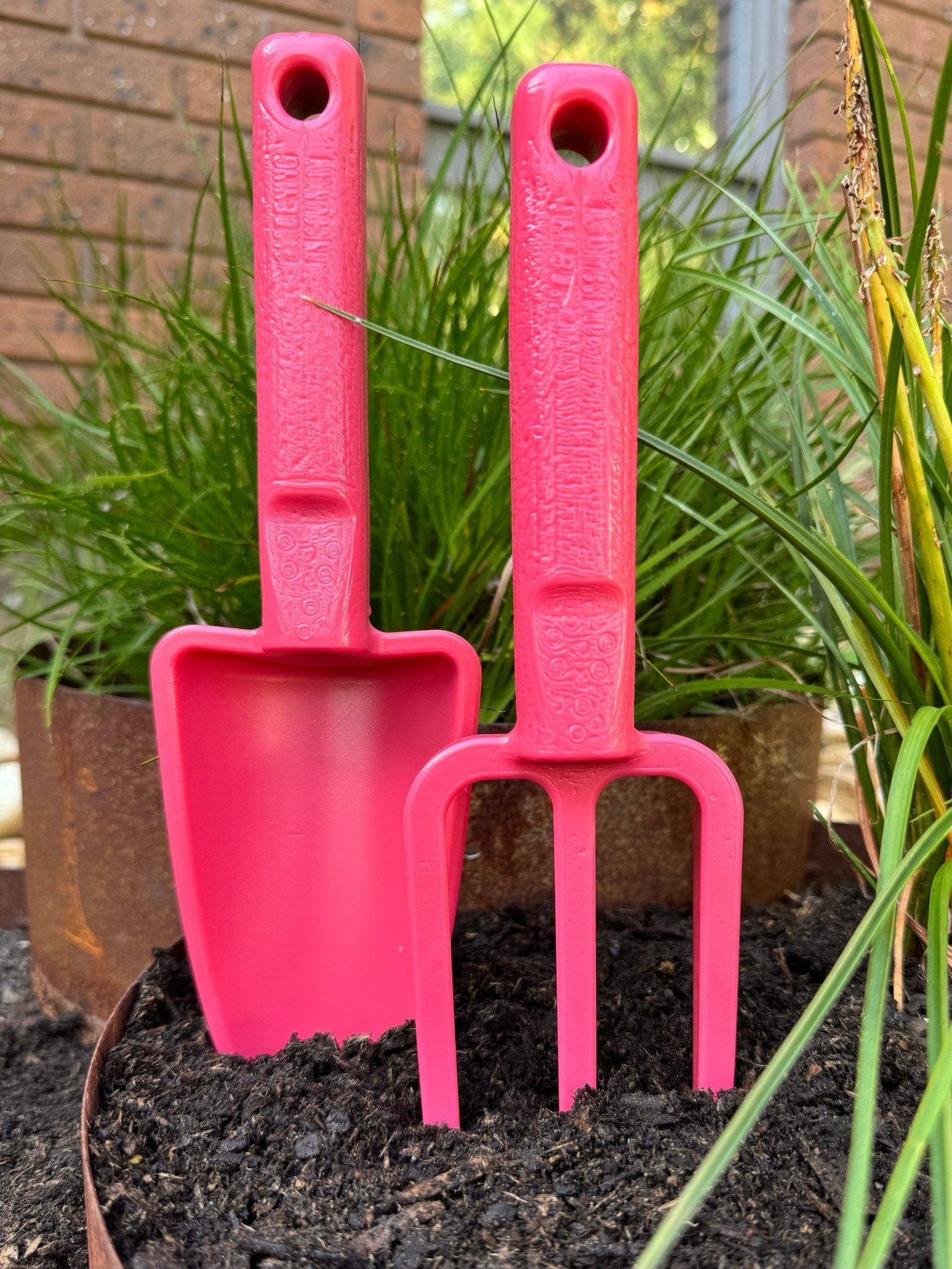 pink-hand-trowel-and-pink-hand-fork-recycled-plastic-garden-toolset-in-garden