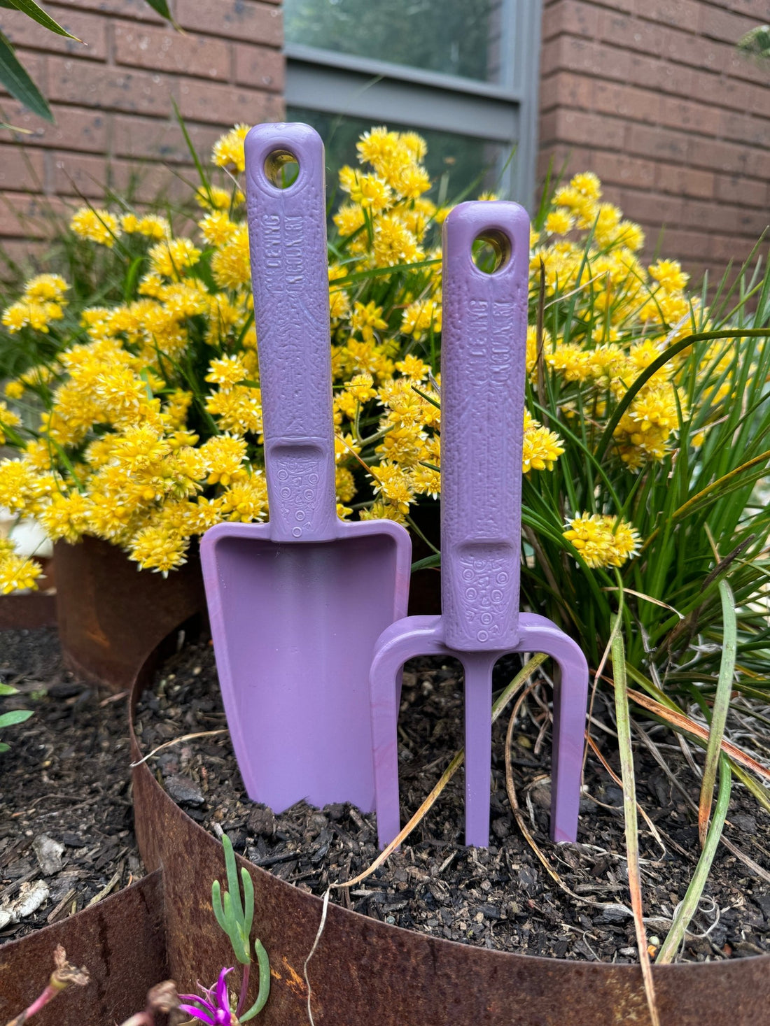 purple-hand-trowel-and-purple-hand-fork-recycled-plastic-garden-toolset-in-garden