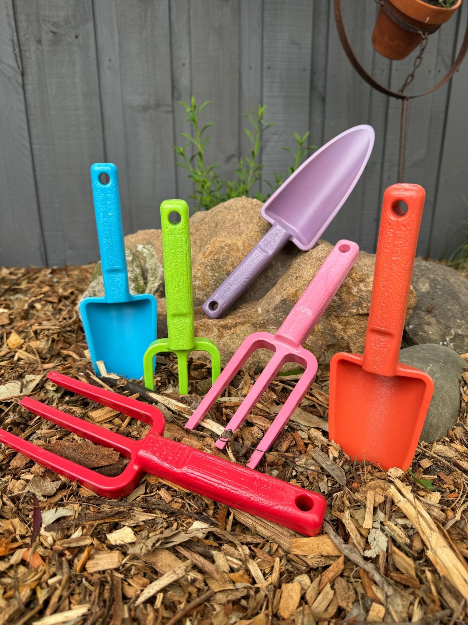Group-shot-of-brightly-coloured-garden-hand-tools-made-from-recycled-plastic-in-garden