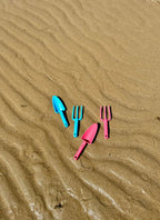 pink-and-blue-kids-garden-tools-laying-on-beach-best-beach-tools