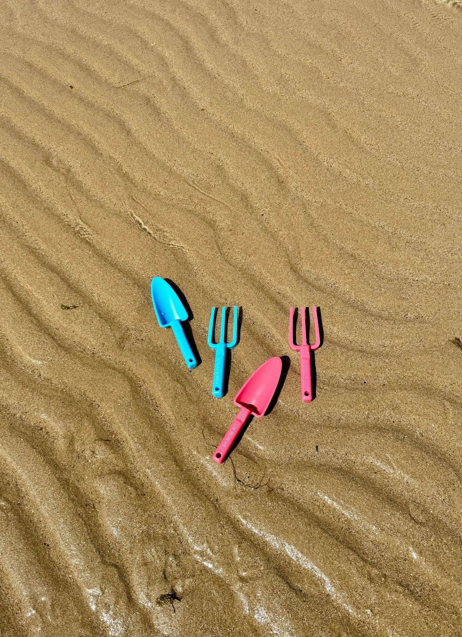 pink-and-blue-kids-garden-tools-laying-on-beach-best-beach-tools