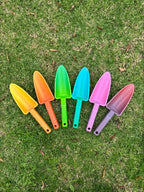 Set of colorful garden shovels on grass