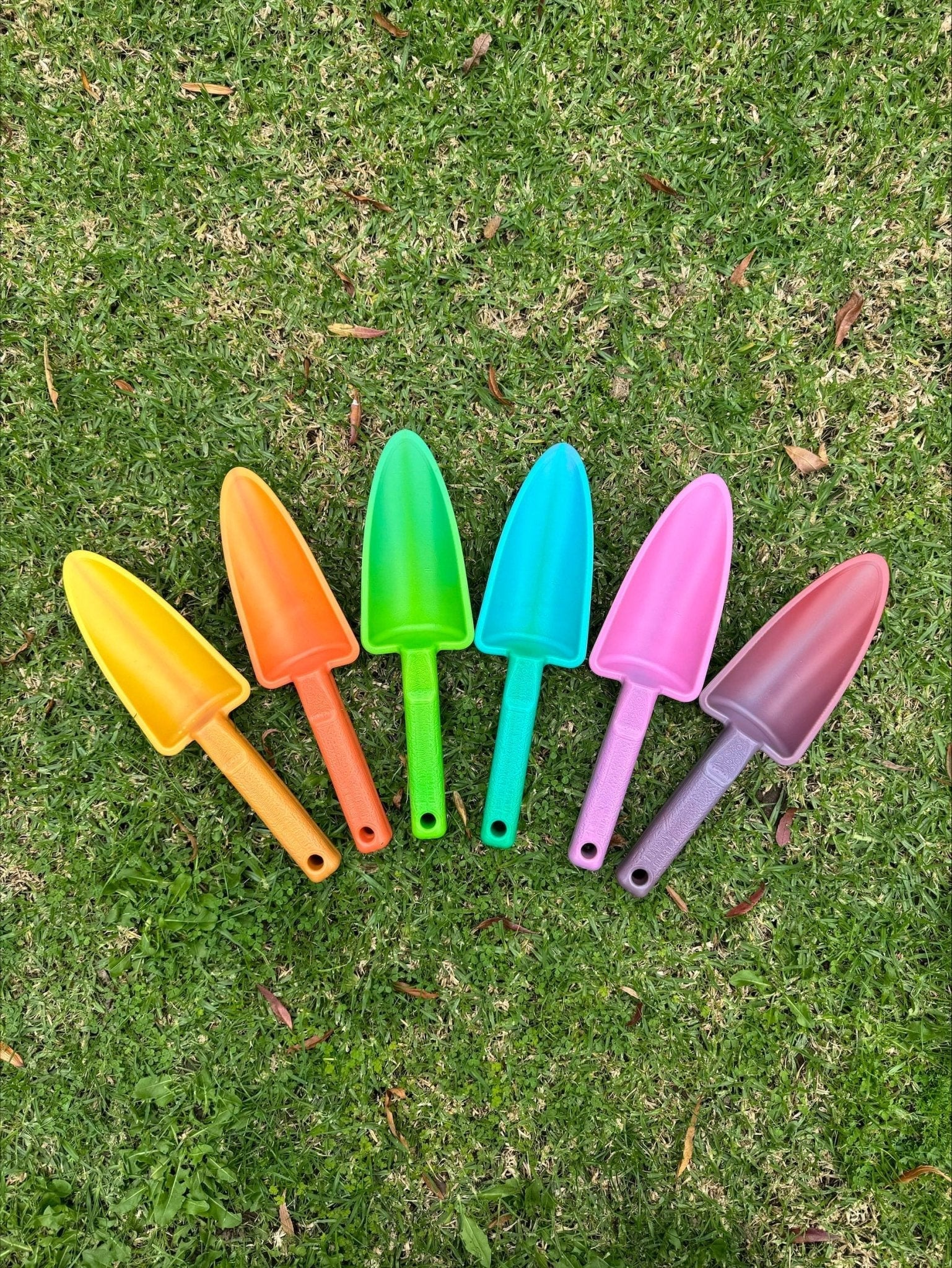 Set of colorful garden shovels on grass